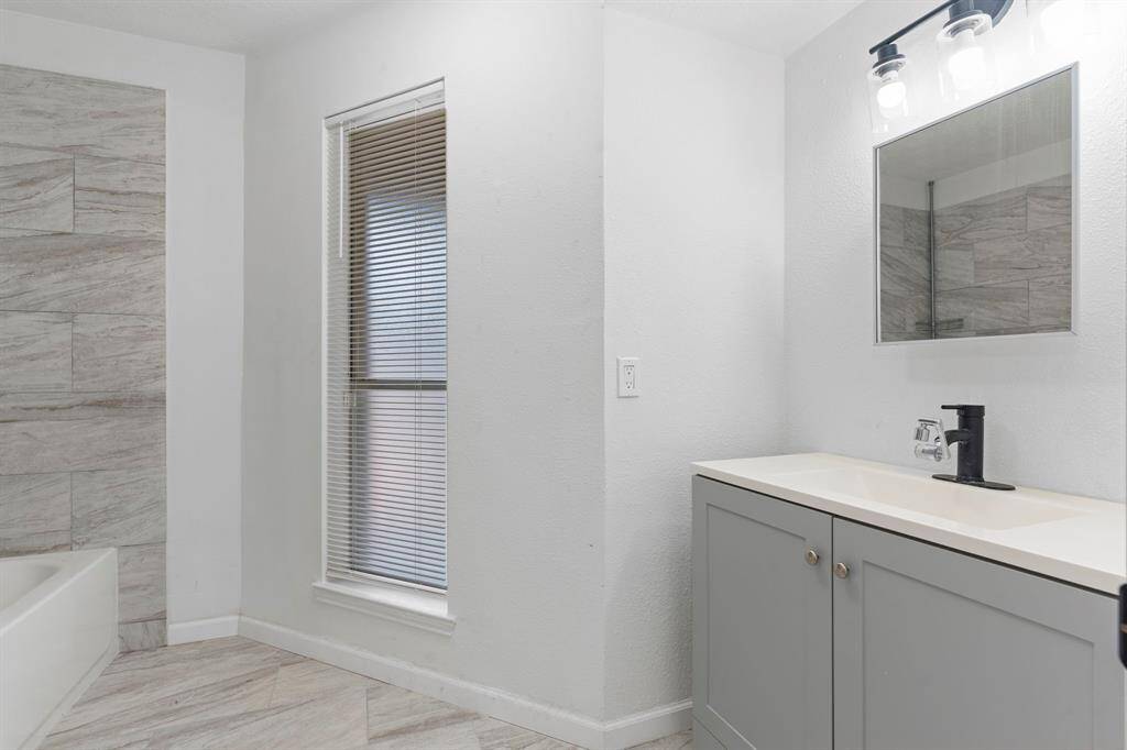 Enjoy a bright Guest suite bathroom featuring a sleek vanity, upgraded fixtures, and a large window for natural light.