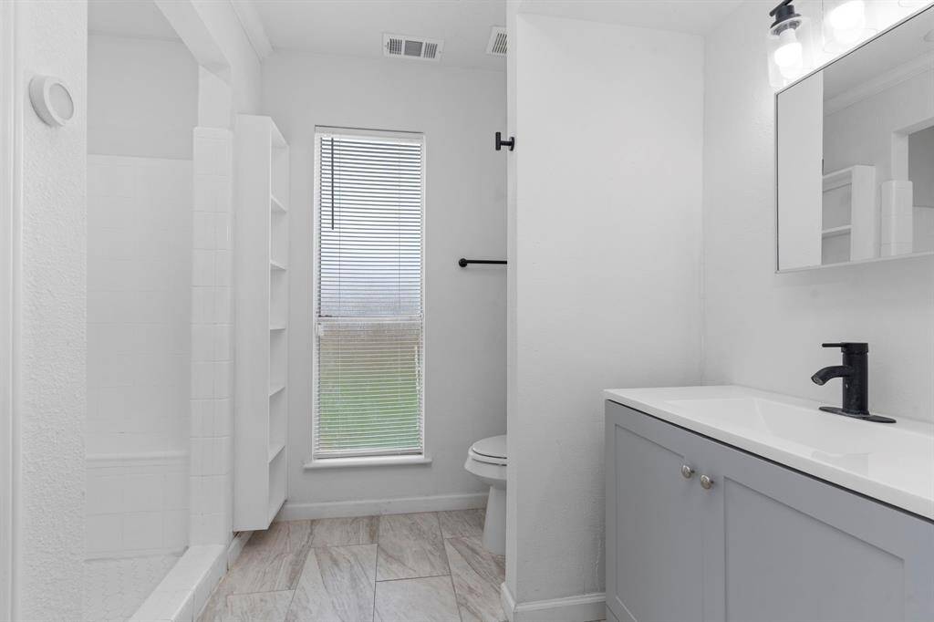Primary bedroom suite looks out to the atrium.  The generously sized bedroom includes large windows, neutral finishes, and private access to the en suite bath.