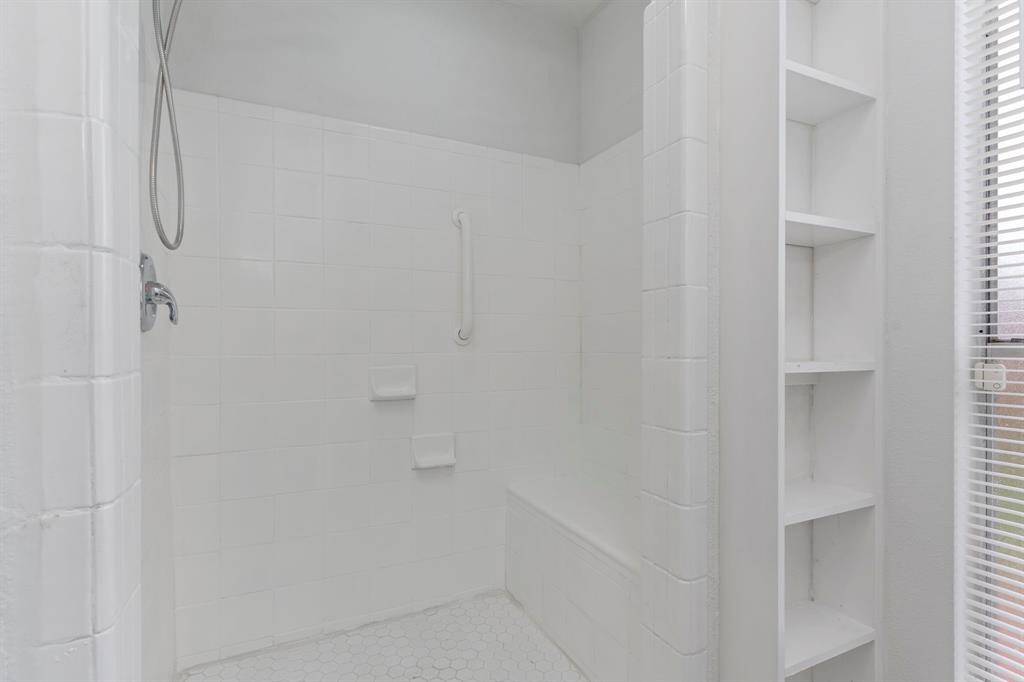 This sleek and simple  Primary bath features a crisp vanity, updated fixtures, and plenty of natural light.