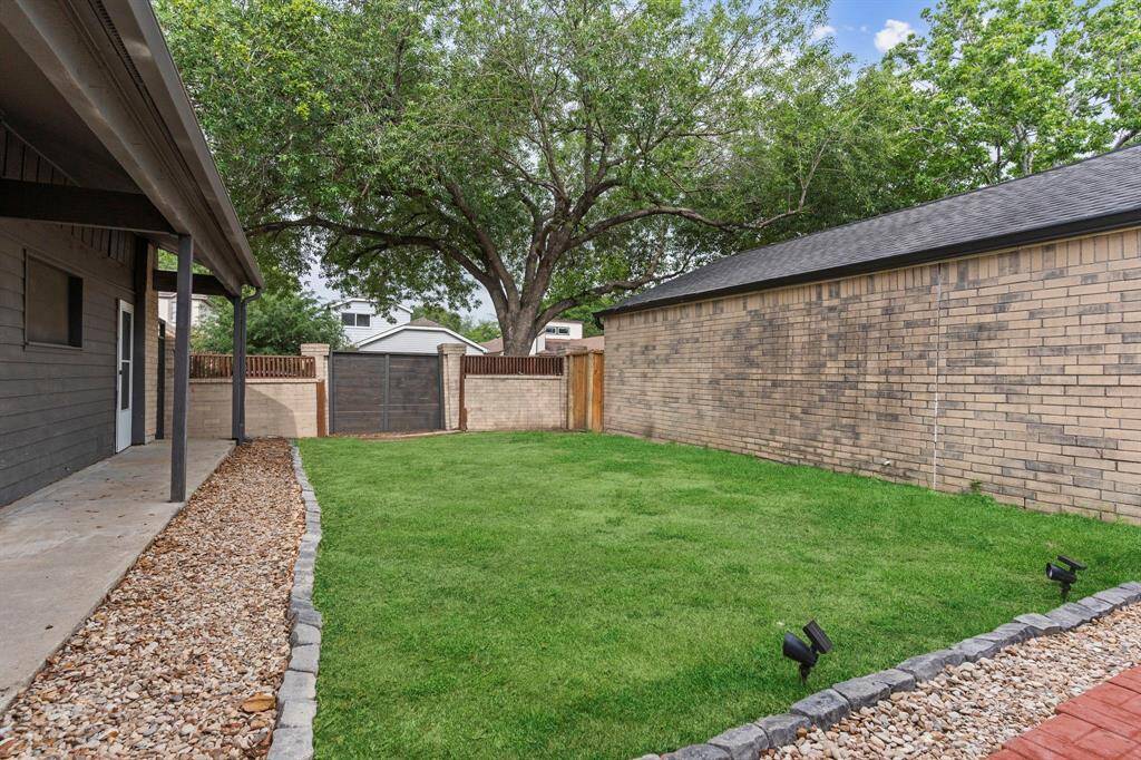 The large backyard includes a covered patio and plenty of room for relaxation, grilling, or play—all fully enclosed for peace of mind.