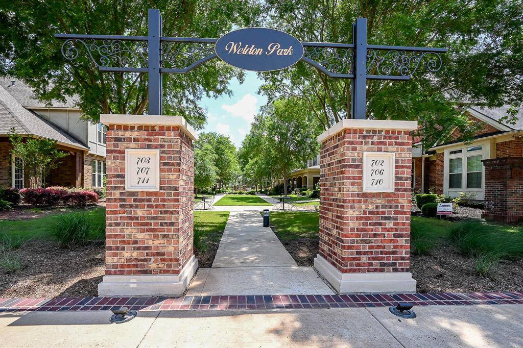 The entrance to Weldon Park, a residential community with well-maintained brick pillars and a landscaped pathway leading through the neighborhood.