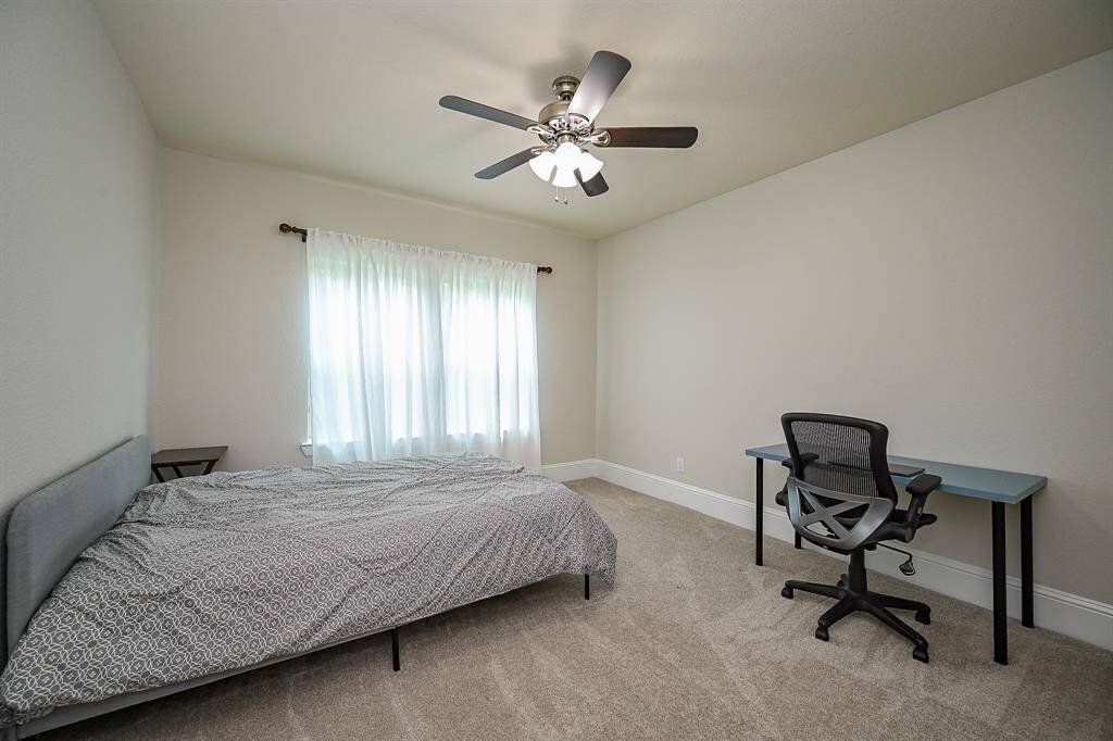 This spacious bedroom features a simple design with neutral walls and carpet.