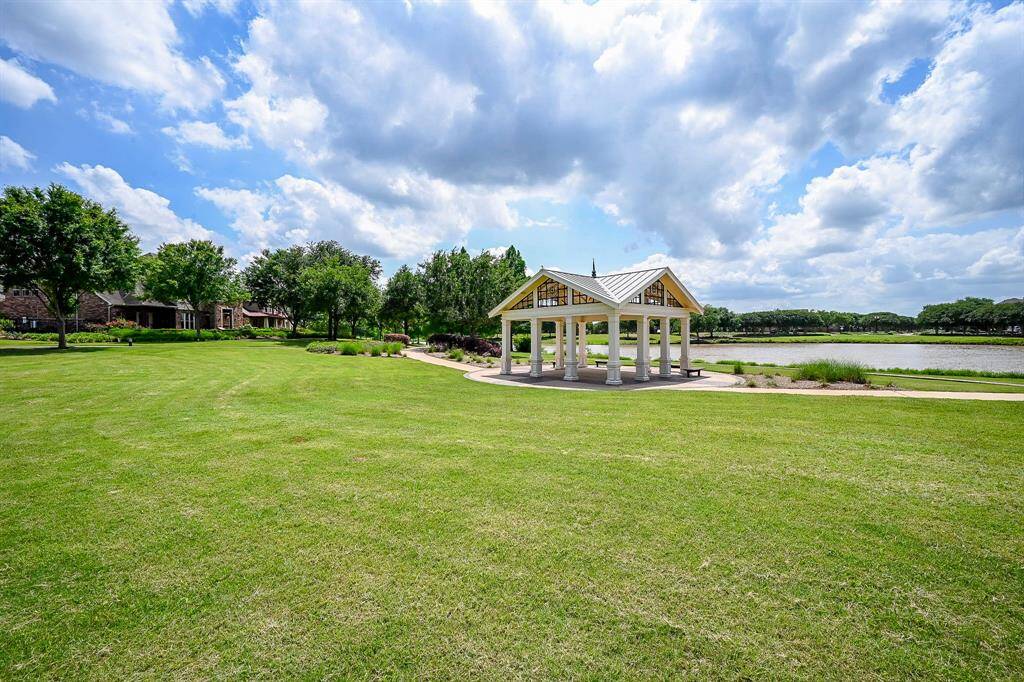 The Telfair neighborhood features a spacious, lush green lawn with a charming gazebo, overlooking a tranquil pond. Perfect for outdoor relaxation and gatherings, surrounded by mature trees and scenic views.