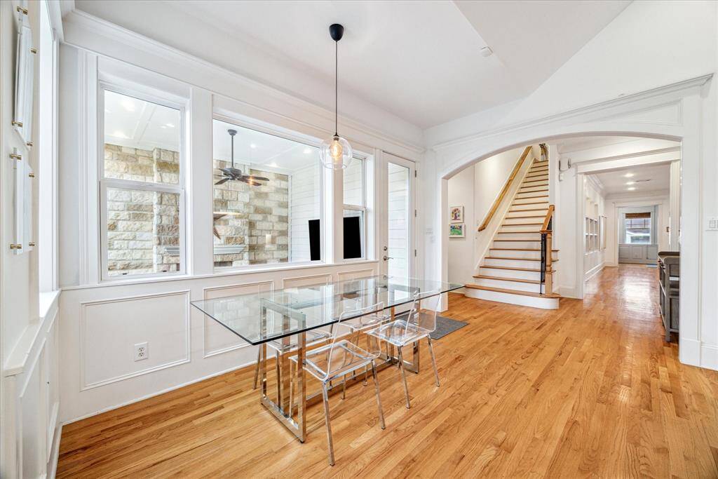The breakfast area sets the stage for morning coffee and casual dining surrounded by wainscoting, oversized windows, and lovely views of the deck and backyard.