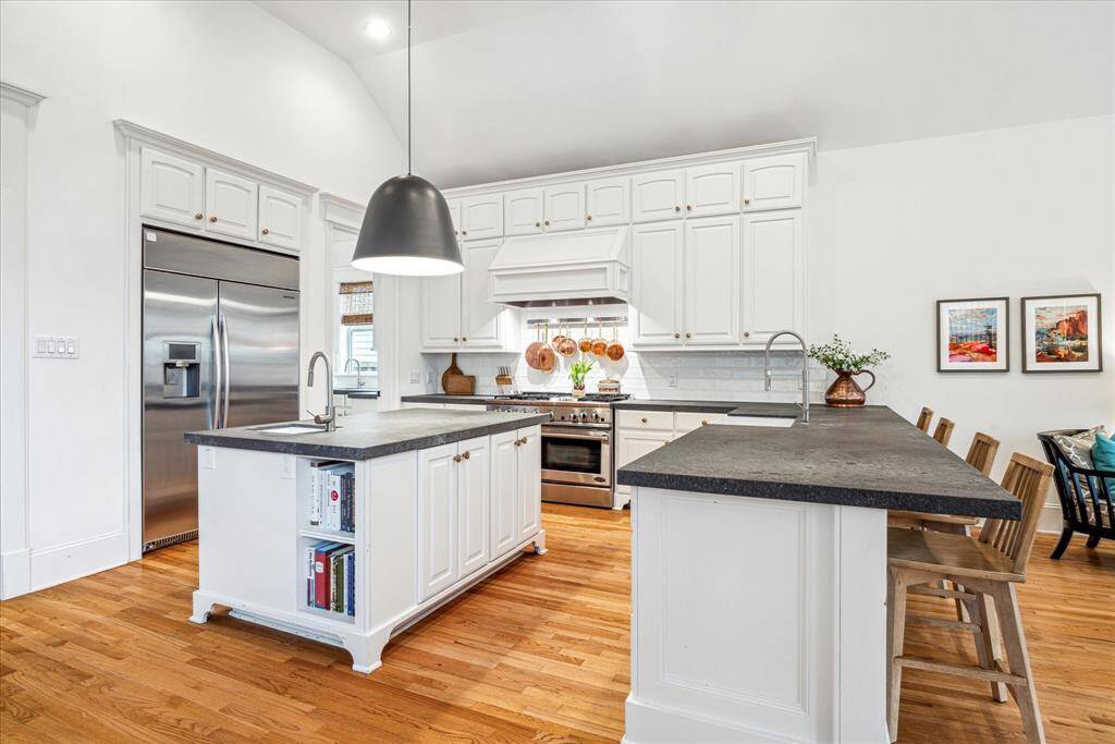The upscale stainless steel appliances include a vented DCS six-burner gas range with double ovens and a griddle, an oversized refrigerator-freezer, a microwave drawer and a dishwasher.