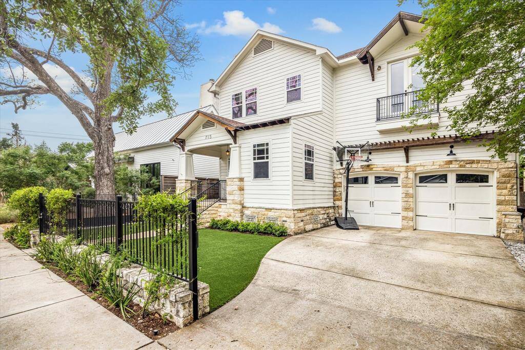 A wide gated driveway and two-car attached garage provide plenty of off-street parking, while a lovely façade trimmed with stone adds wonderful curb appeal.