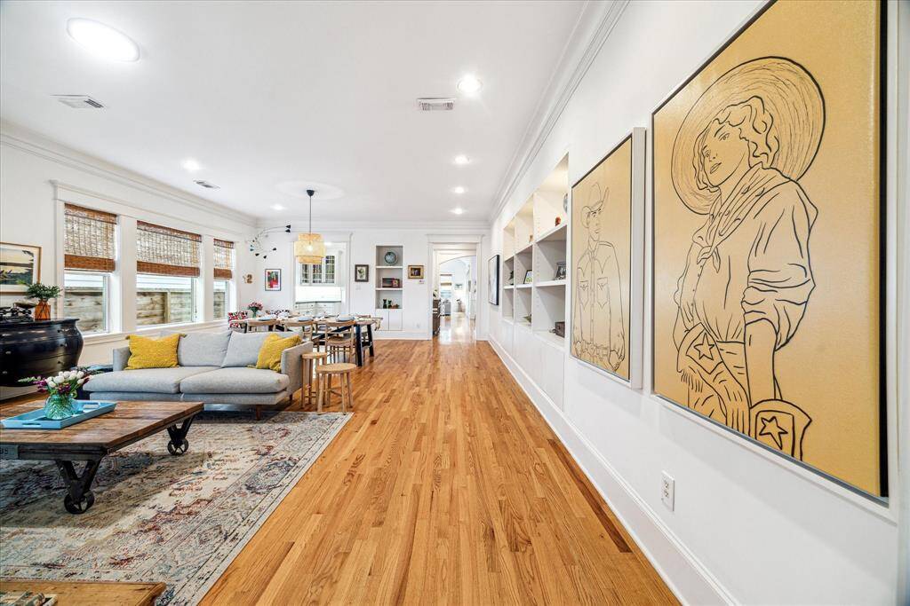 This bright and airy residence features 12-foot-tall ceilings dotted with recessed and designer lighting, tall baseboards, crown molding, built-ins and oversized windows trimmed with custom woven shades.