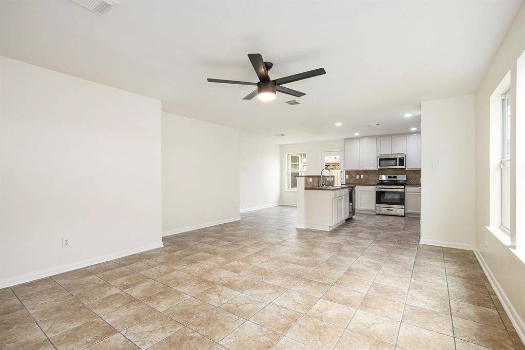 This view, similar to the previous one, also reveals the back kitchenette area—an ideal spot to create a cozy breakfast nook, complementing the open-concept kitchen and island for a perfect balance of style and functionality.