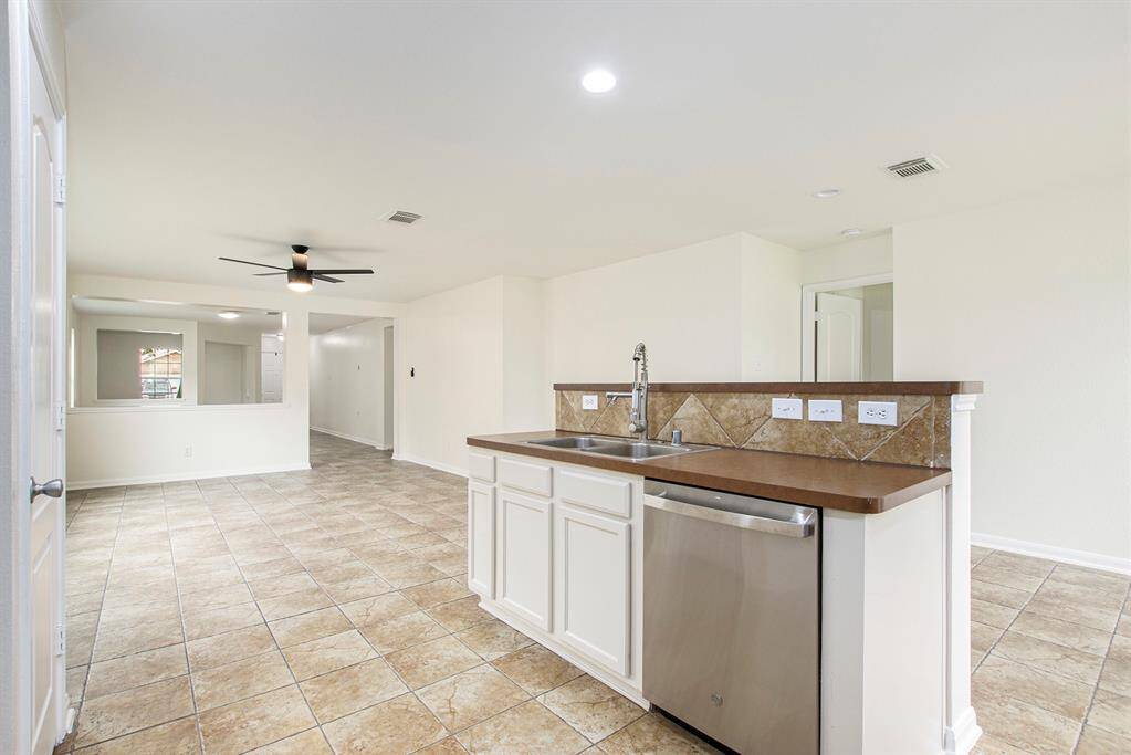 This view showcases the spacious kitchen island, with a seamless connection to the open living area and stunning views toward the front of the home, making it perfect for both cooking and entertaining.