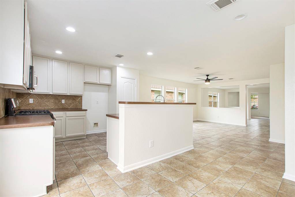 Standing in the back corner where the breakfast nook would be, this view provides a clearer perspective of the kitchen island, along with the second entry from the back door, leading directly into the heart of the home.