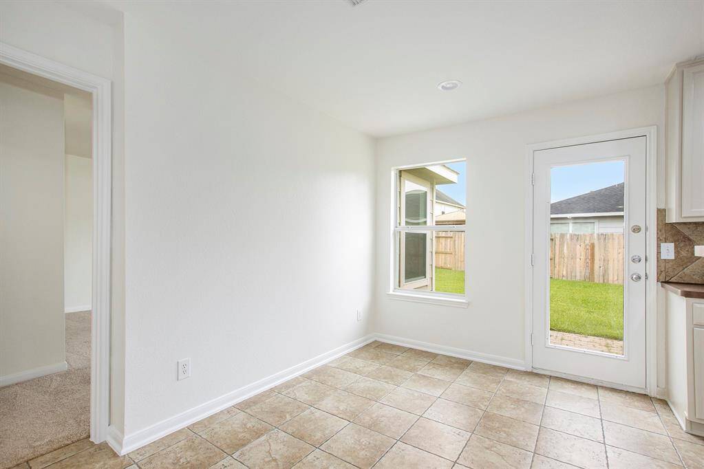 This view of the breakfast nook area also includes a door leading into the primary bedroom, seamlessly connecting the cozy eating space with the private retreat.