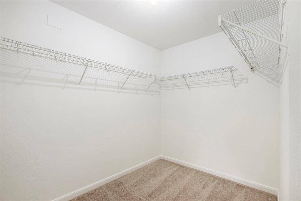 The walk-in closet offers an abundance of space, allowing you to customize and organize it to meet your exact needs and expectations, creating the perfect storage solution.