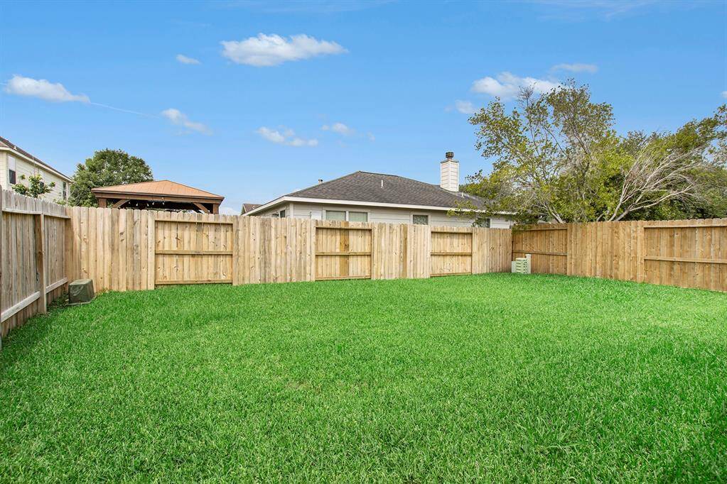 The spacious backyard is perfect for outdoor activities, complete with a built-in sprinkler system to keep the grass lush and green year-round, creating an inviting and low-maintenance space for relaxation or entertaining.