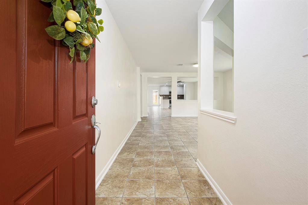 Step through the bold red door into a sun-drenched, open-concept interior that instantly feels like home—bright, airy, and ready to impress!