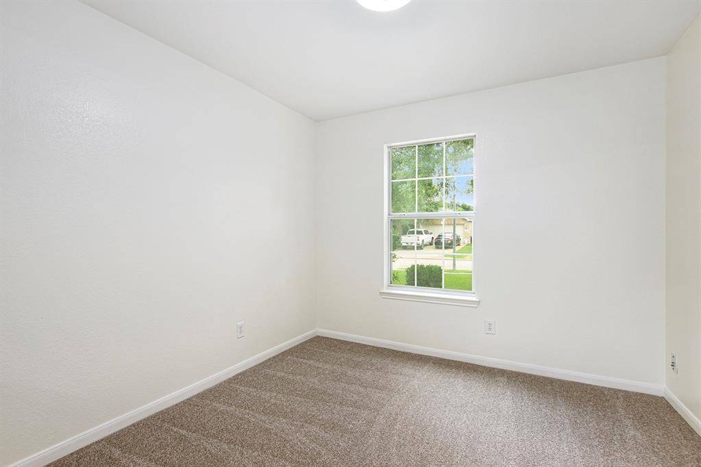 A closer look reveals this bright, flexible space with large front-facing windows that flood the room with natural light and offer a clear view of the driveway, perfect for keeping an eye out or simply enjoying the neighborhood scenery.