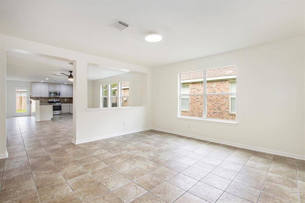 Stepping into this defined yet versatile area, you’re welcomed into a space that can easily serve as your main living room or a formal dining area, tailored to fit your lifestyle and design vision.