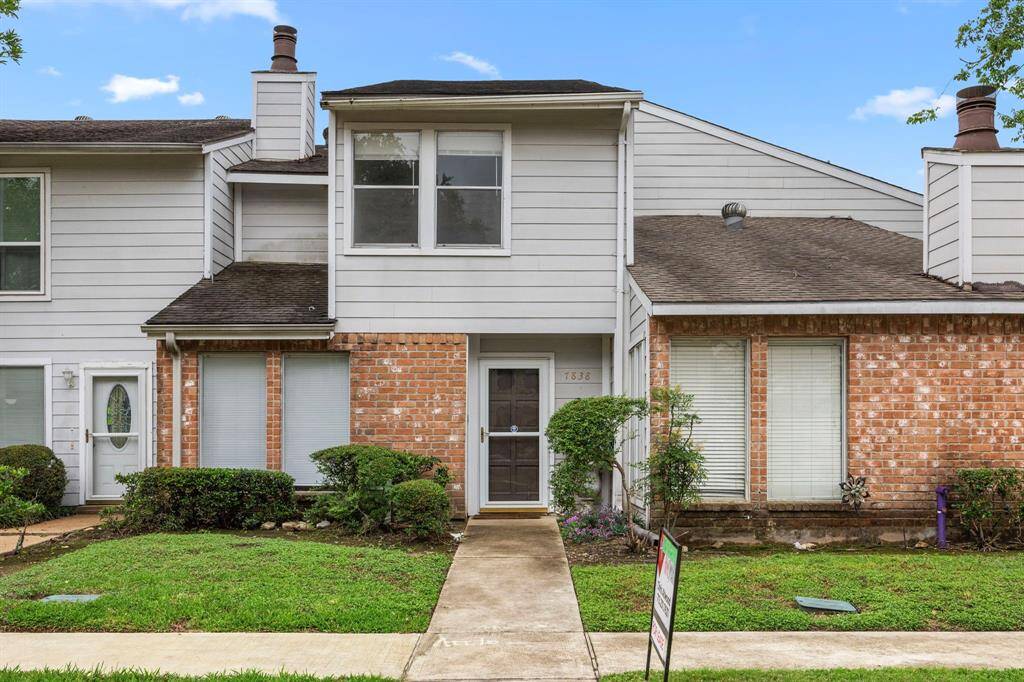 This is a charming two-story townhouse with a mix of brick and siding exterior. It features a front walkway with well-maintained landscaping and a small front yard. The home has multiple windows for natural light and a cozy entrance. Ideal for buyers seeking a comfortable, low-maintenance property.