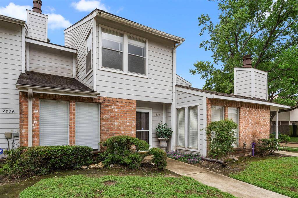 This is a charming two-story townhouse with a mix of brick and siding exterior. It features a front walkway with well-maintained landscaping and a small front yard. The home has multiple windows for natural light and a cozy entrance. Ideal for buyers seeking a comfortable, low-maintenance property.