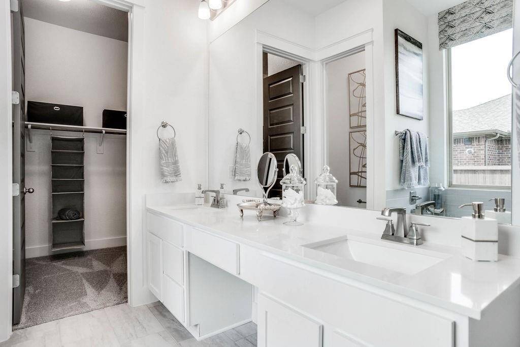 Representative photo of the Cypress plan Primary Bathroom. Shown to highlight the elegant finishes, from the dazzling floors to the chic light fixtures, reflect a careful attention to detail that feels both luxurious and comforting.
