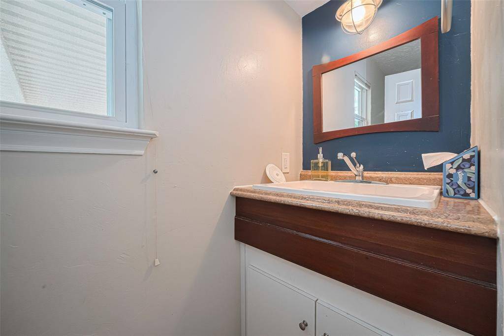 Half bath is conveniently located for guests downstairs or outside by the pool