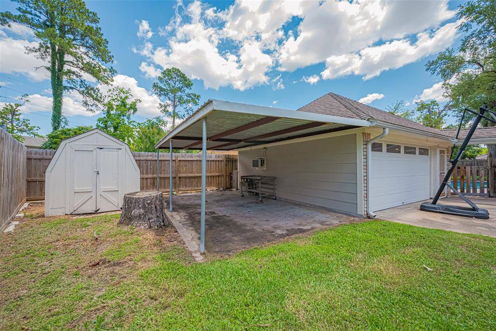 Covered area off the garage is perfect for a workshop space or shaded play area.