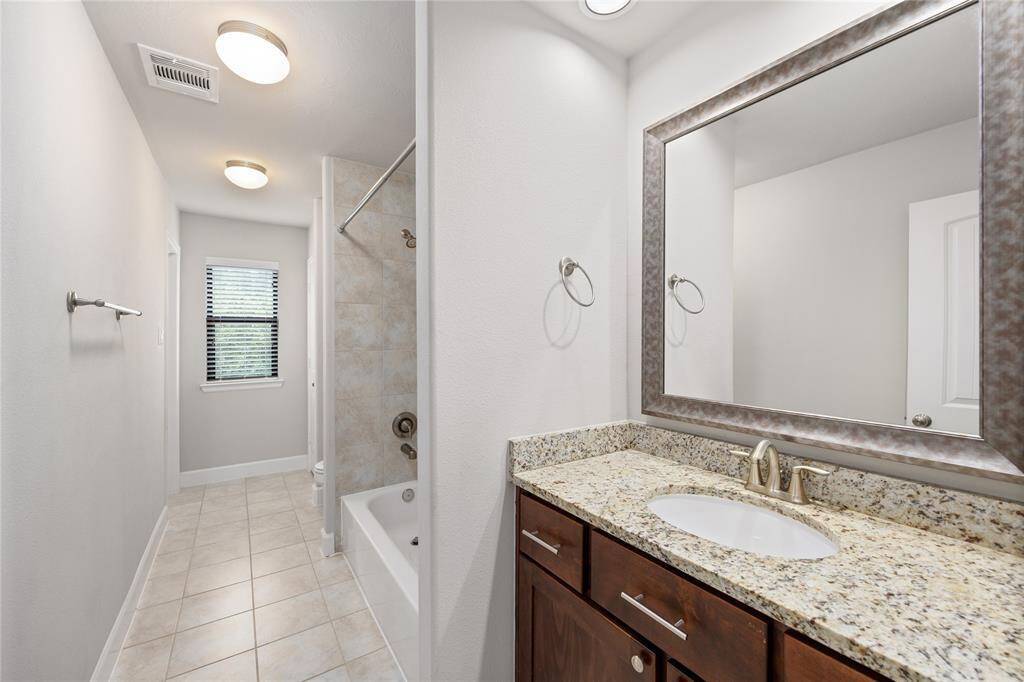 view of the 2nd full bathroom adjoining the two secondary rooms.