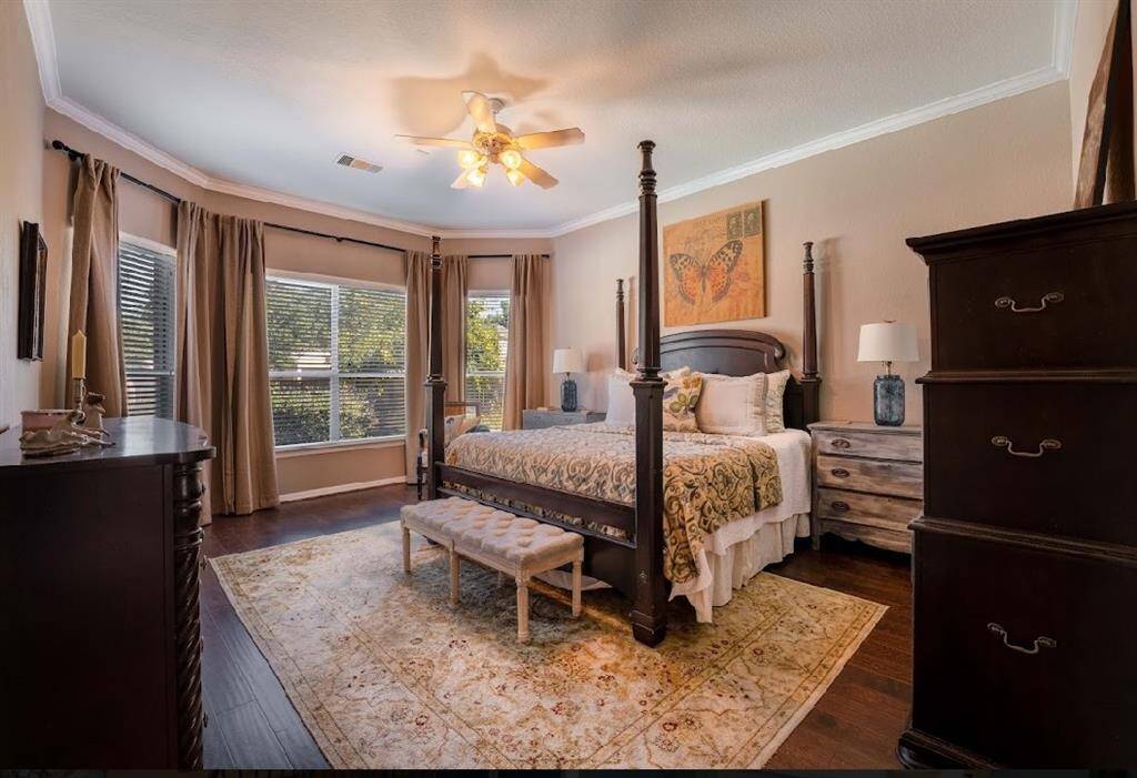 Large windows brighten up this primary bedroom and the richness of the floors leave a cozy feel.