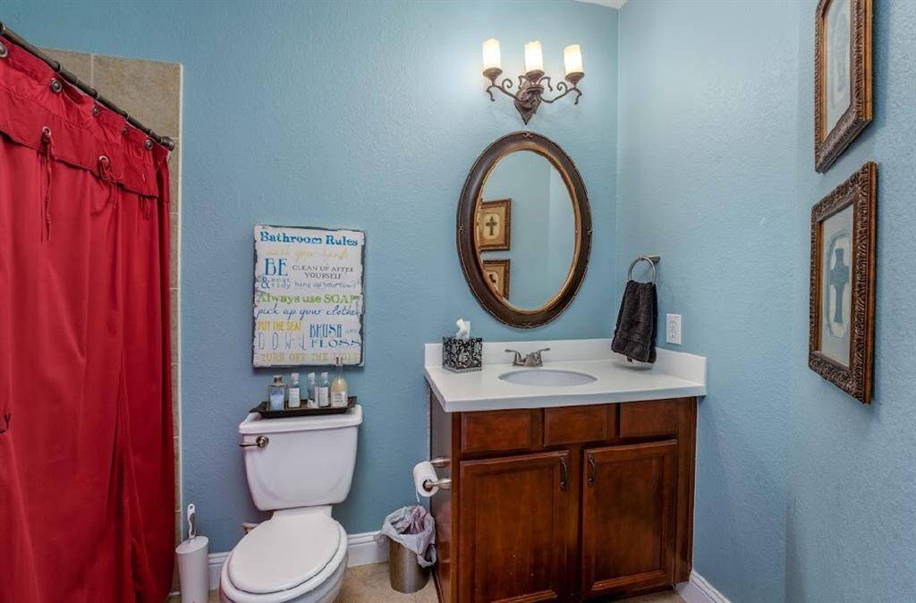 The hall bathroom upstairs is located just outside of a bedroom and game room.