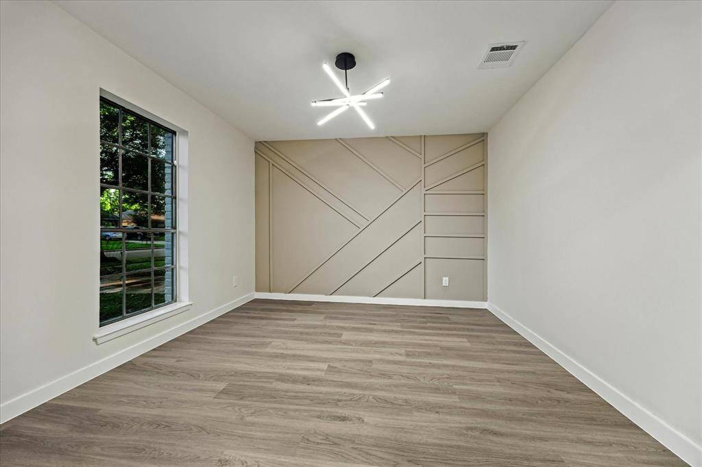 Versatile room highlighted by a custom trim accent wall and large front facing window