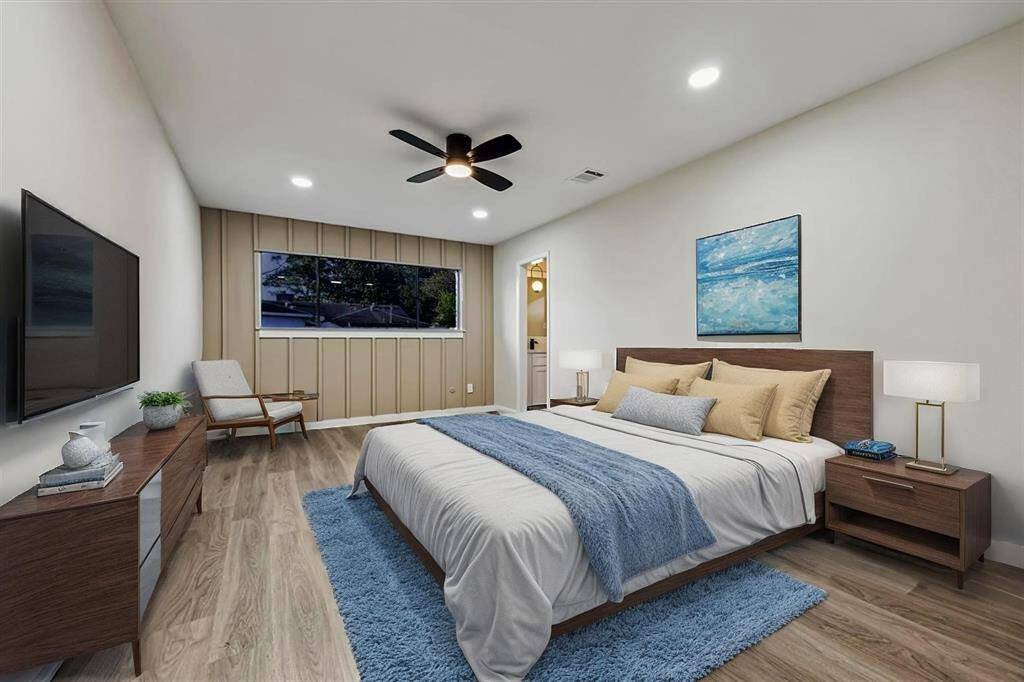 Primary Bedroom w/ accent wall paneling, recessed lighting, and ensuite bath access