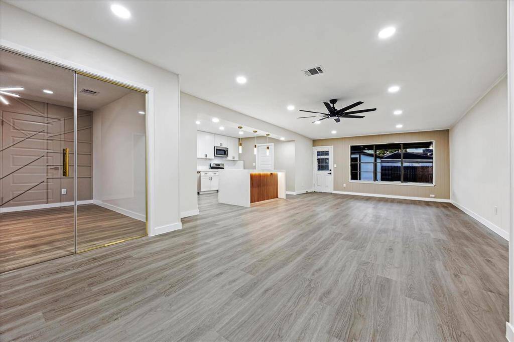 Spacious Open Layout feat. recessed lighting, luxury vinyl plank, and sleek matte black ceiling fan for a contemporary touch