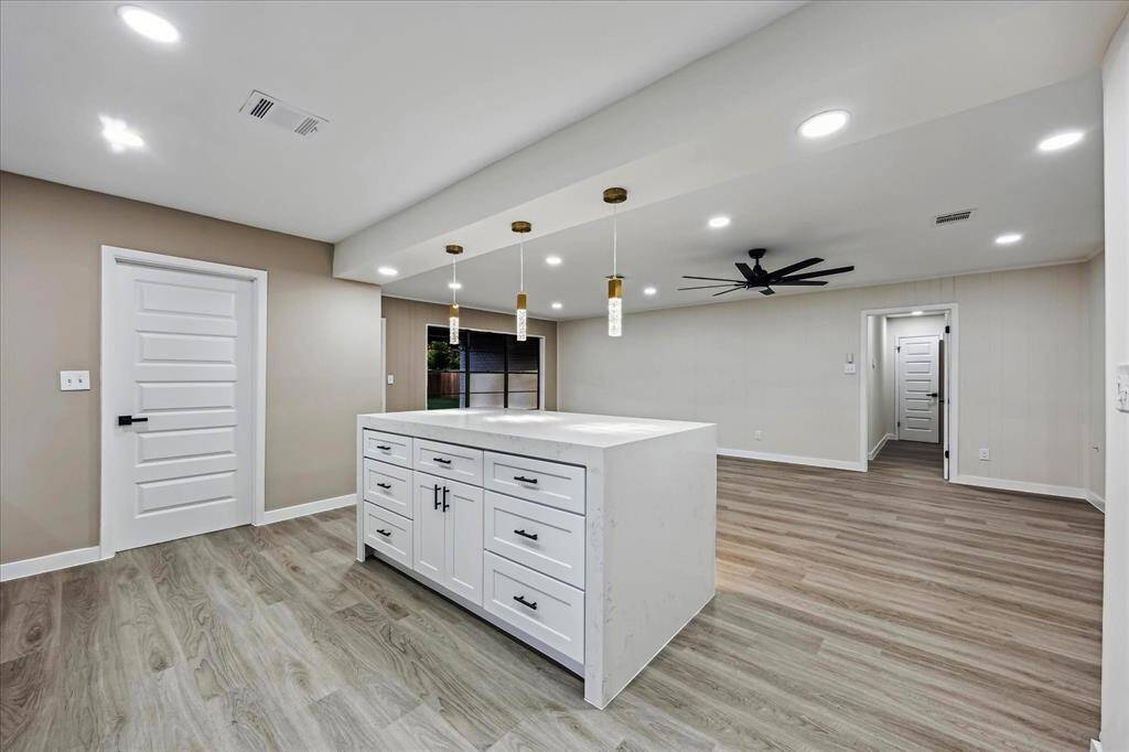 Stunning Gourmet kitchen with quartz waterfall island, wood slat paneling