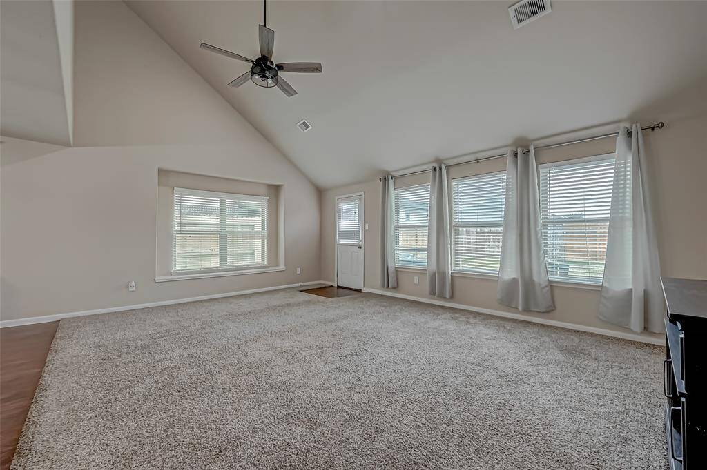 The living room is bathed in natural light, thanks to an abundance of large windows that create a bright, airy atmosphere. These expansive windows not only fill the space with sunlight but also offer stunning views, making the room feel open and seamlessly connected to the outdoors.