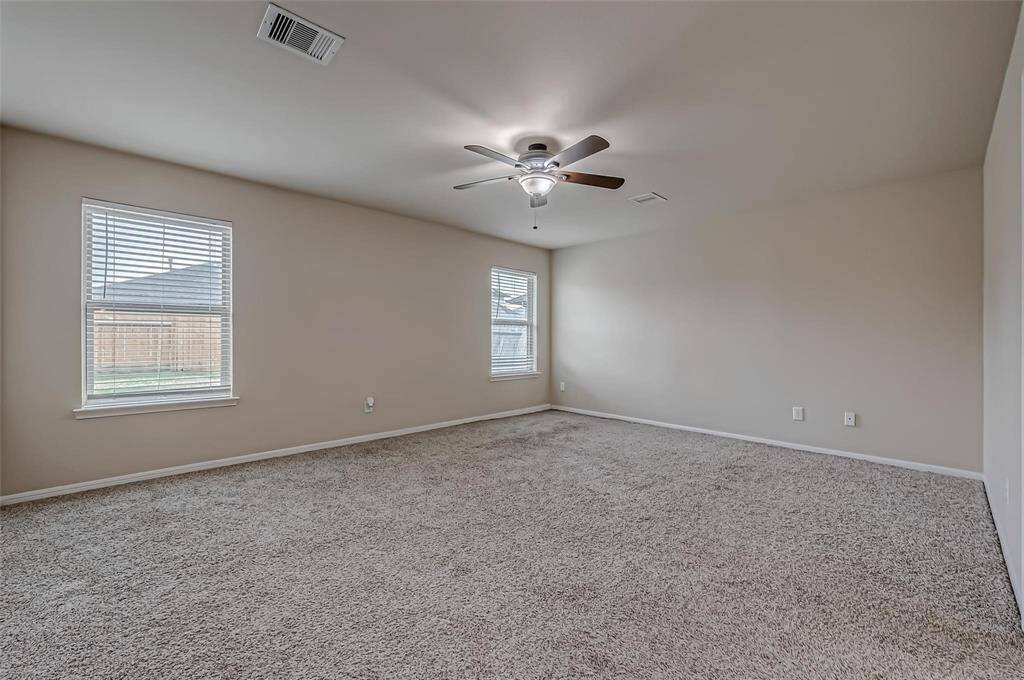 The primary bedroom features large windows that fill the space with natural light, creating a bright and welcoming atmosphere. This abundance of sunlight enhances the room’s sense of openness, making it a serene and peaceful retreat.
