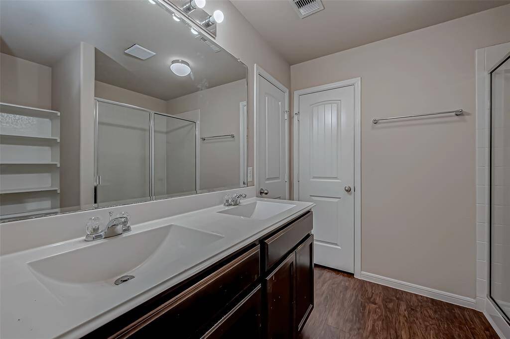 The primary bath features dual cultured marble sinks, combining elegance and durability for a stylish and functional space. Espresso cabinets beautifully complement the sinks, adding a rich, modern touch to the room’s design. The extended shower creates a luxurious, spacious retreat, enhancing the bathroom's appeal and offering a spa-like atmosphere.