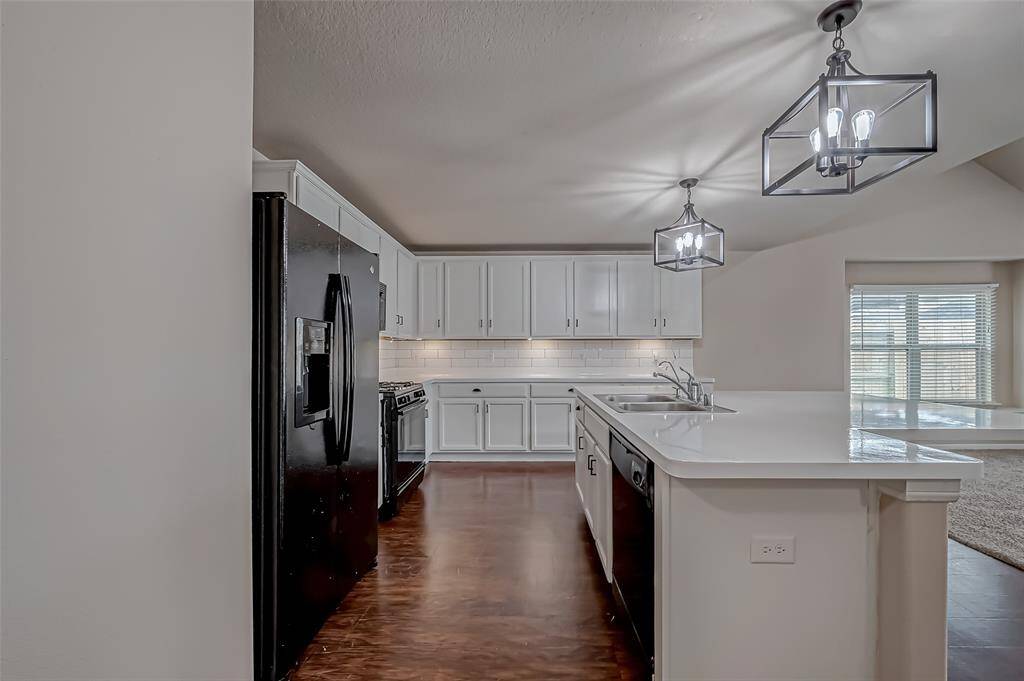 Modern pendant lights add a touch of elegance to the kitchen, creating a warm and inviting atmosphere. Under-cabinet lighting enhances both style and functionality, illuminating the workspace for easy meal prep and everyday cooking