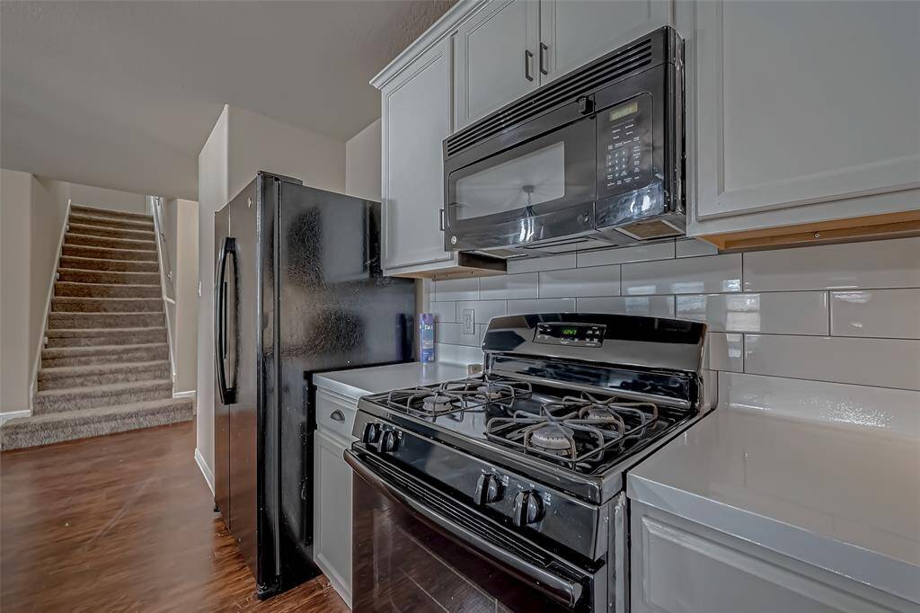 The modern white kitchen showcases sleek cabinetry and striking black appliances, creating a bold contrast that adds a touch of sophistication. Thoughtfully designed for both everyday functionality and stylish entertaining, it’s the perfect space for bringing everyone together