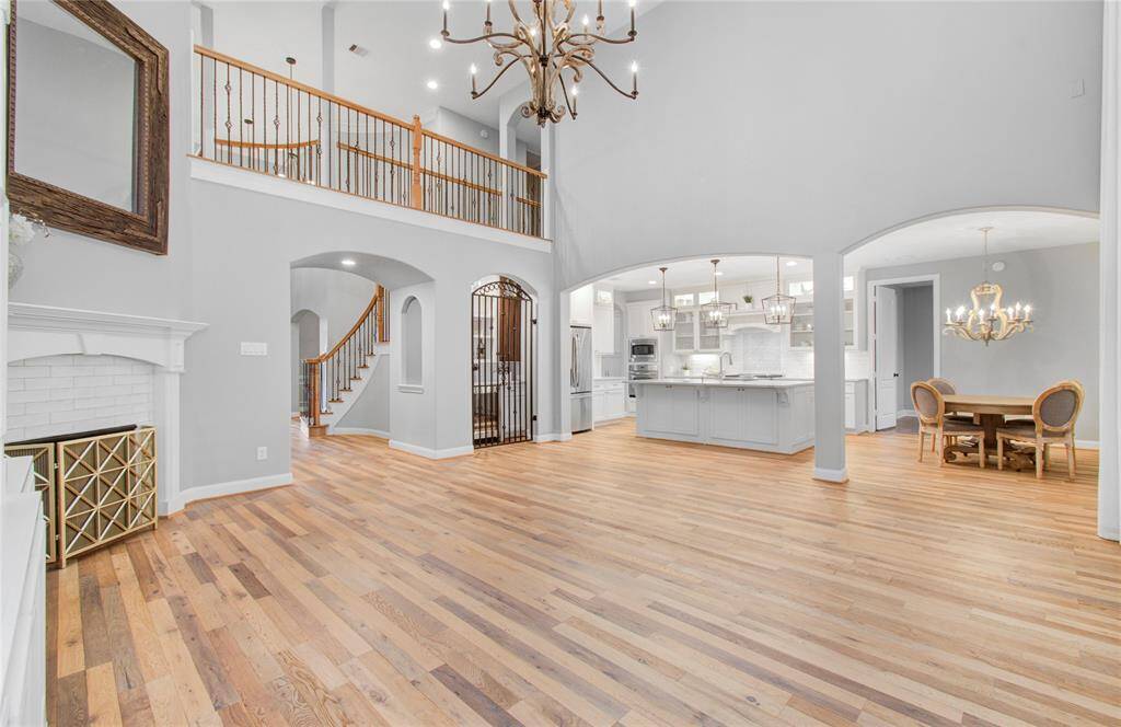 This spacious open floor plan with high ceilings and elegant hardwood floors. The living area includes a gas fireplace, while the modern kitchen boasts pendant lighting and an island.