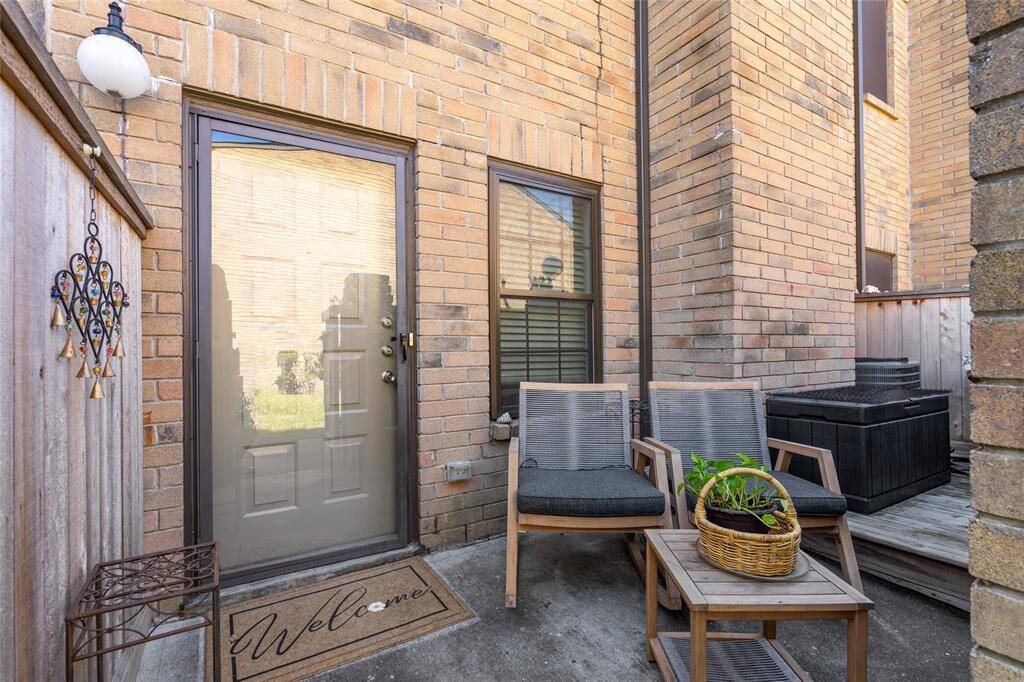Charming and private, this inviting front patio offers the perfect space to enjoy your morning coffee or unwind in the fresh air. Featuring a cozy seating area, stylish brick exterior, and a welcoming glass door entry, this space sets the tone for comfortable living. A touch of greenery and decorative accents add to the warm and inviting ambiance.
