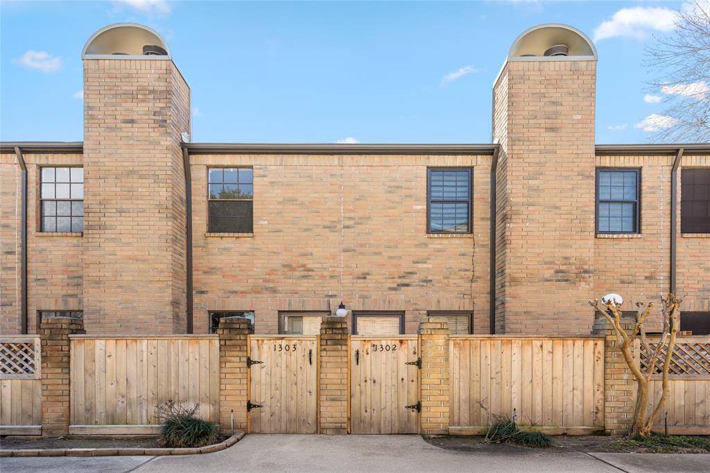 Welcome to 9850 Pagewood Lane #1302, a charming townhome with a timeless brick façade and a private gated entry. The warm brick exterior, accented by classic black-trim windows and dual chimneys, exudes character and curb appeal. A fenced front patio adds an extra layer of privacy, making this home a perfect retreat in a well-maintained community.