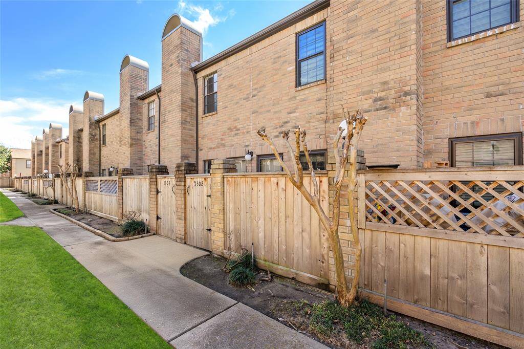 Nestled in a well-maintained community, 9850 Pagewood Lane #1302 offers a charming townhome with a classic brick façade and a private gated entrance. A beautifully landscaped walkway leads to the front patio, providing a peaceful retreat. The striking row of chimneys adds architectural character, while the wooden fence ensures privacy. Enjoy the blend of convenience and charm in this inviting space.