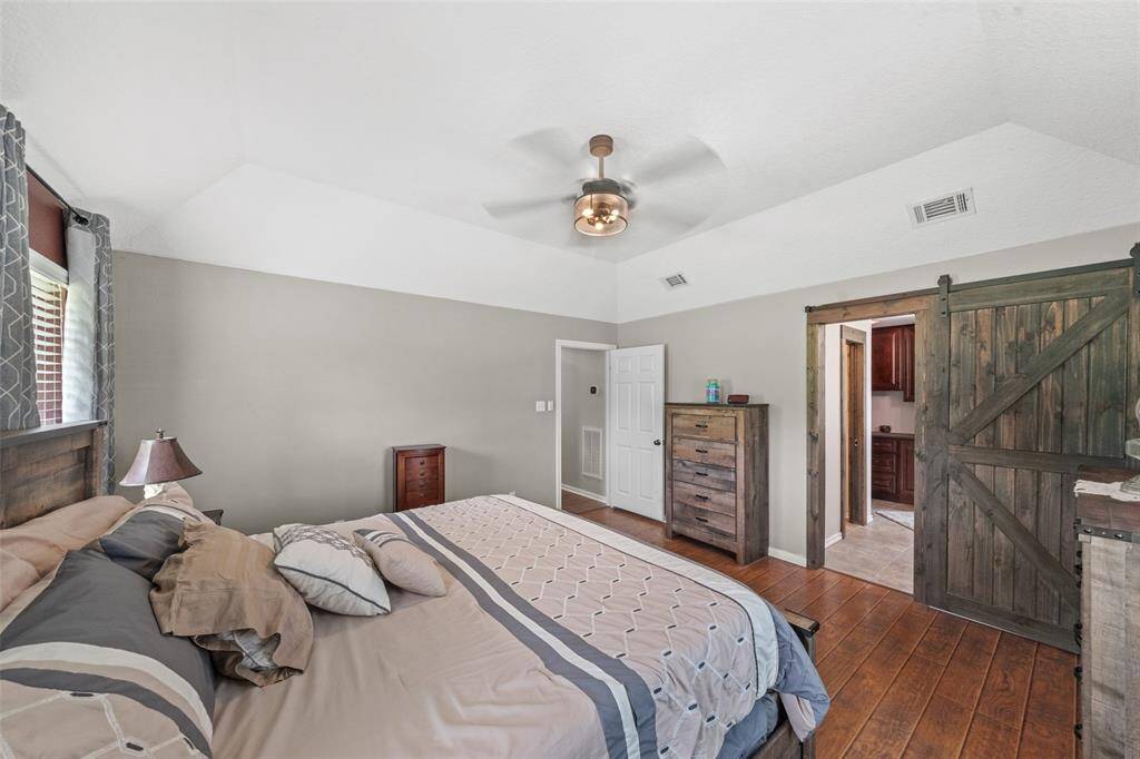 Sliding barn door opens to primary ensuite bath & walkin closet