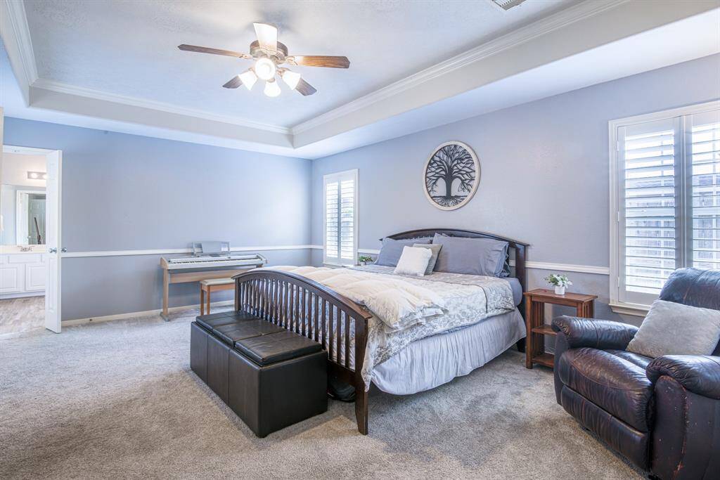 A tray ceiling with crown molding and plantation shutters on all of the windows makes this a timelessly elegant retreat.