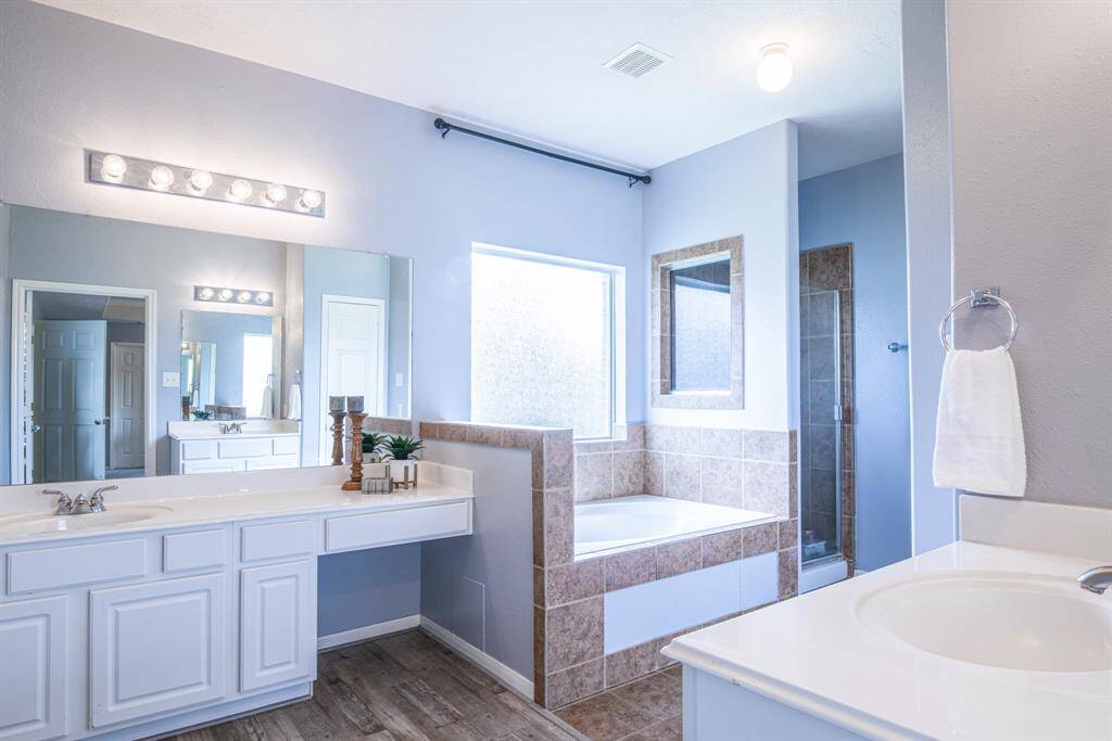 The spacious ensuite bathroom has a jetted tub and separate shower, plus two large vanities with their own sinks.