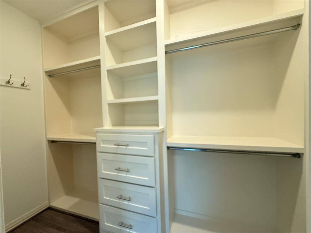Spacious walk-in closet with built-in shelves, drawers, and hanging rods, offering ample storage and organization options.
