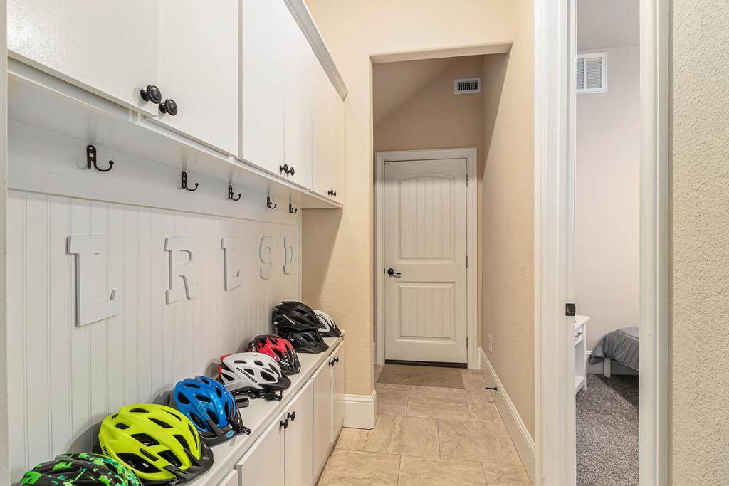 The mud room conveniently located just off the garage, offers a practical space for organizing outwear and footwear.