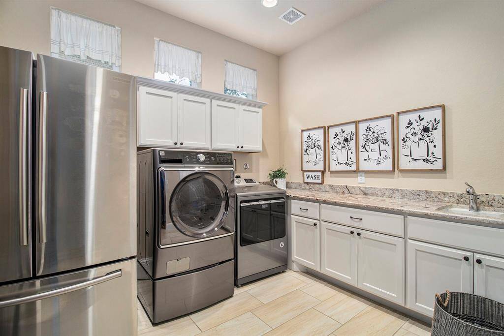 The spacious laundry room offers ample space for all your laundry needs. Equipped with plenty of storage and counter space, this room is designed for efficiency and convenience.