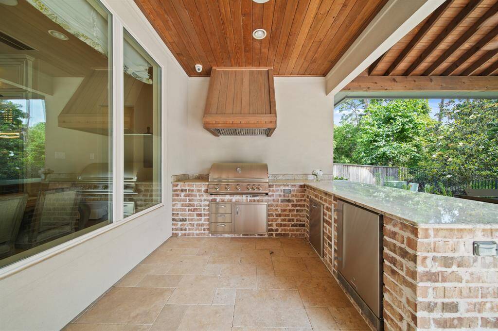 Experience the ultimate in outdoor living with a stunning exterior retreat that features elegant travertine decking. This space boasts a fully equipped outdoor kitchen with a high-end grill.
