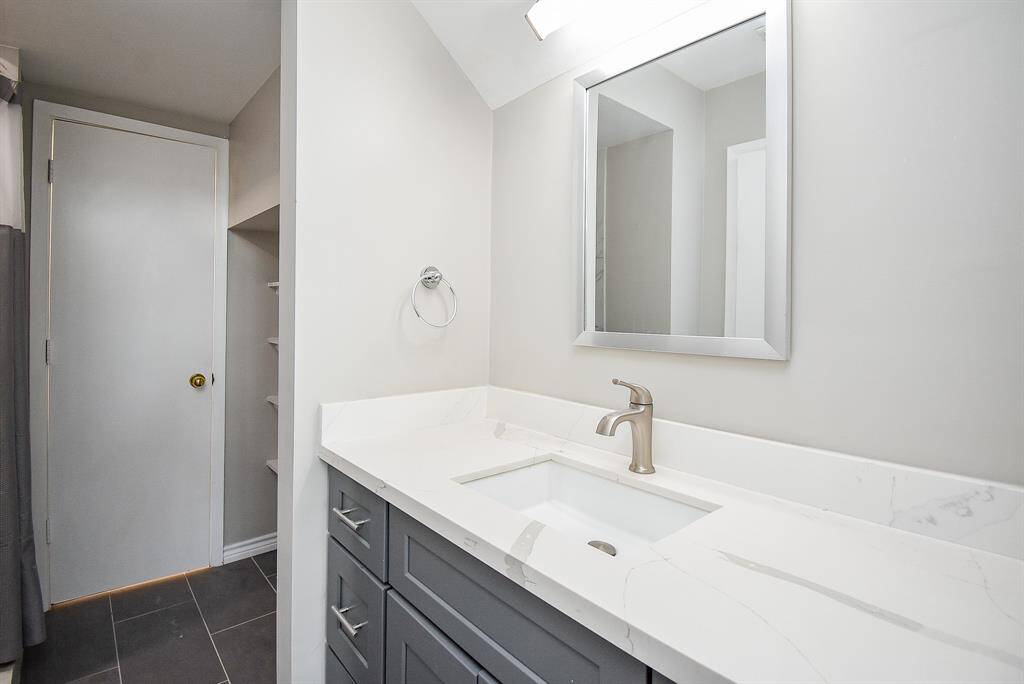 A stylish vanity sits next to the walk-in shower.