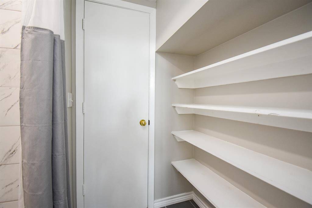 Bathroom with built-in white shelves providing ample storage space.